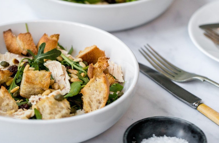 Chicken and toasted bread salad with raisins, pine nuts and capers